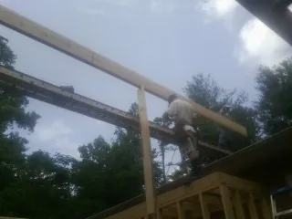 Carpenter setting a ridge beam over a new addition frame — Ice Dam Removal by Roofing Brothers in Orefield