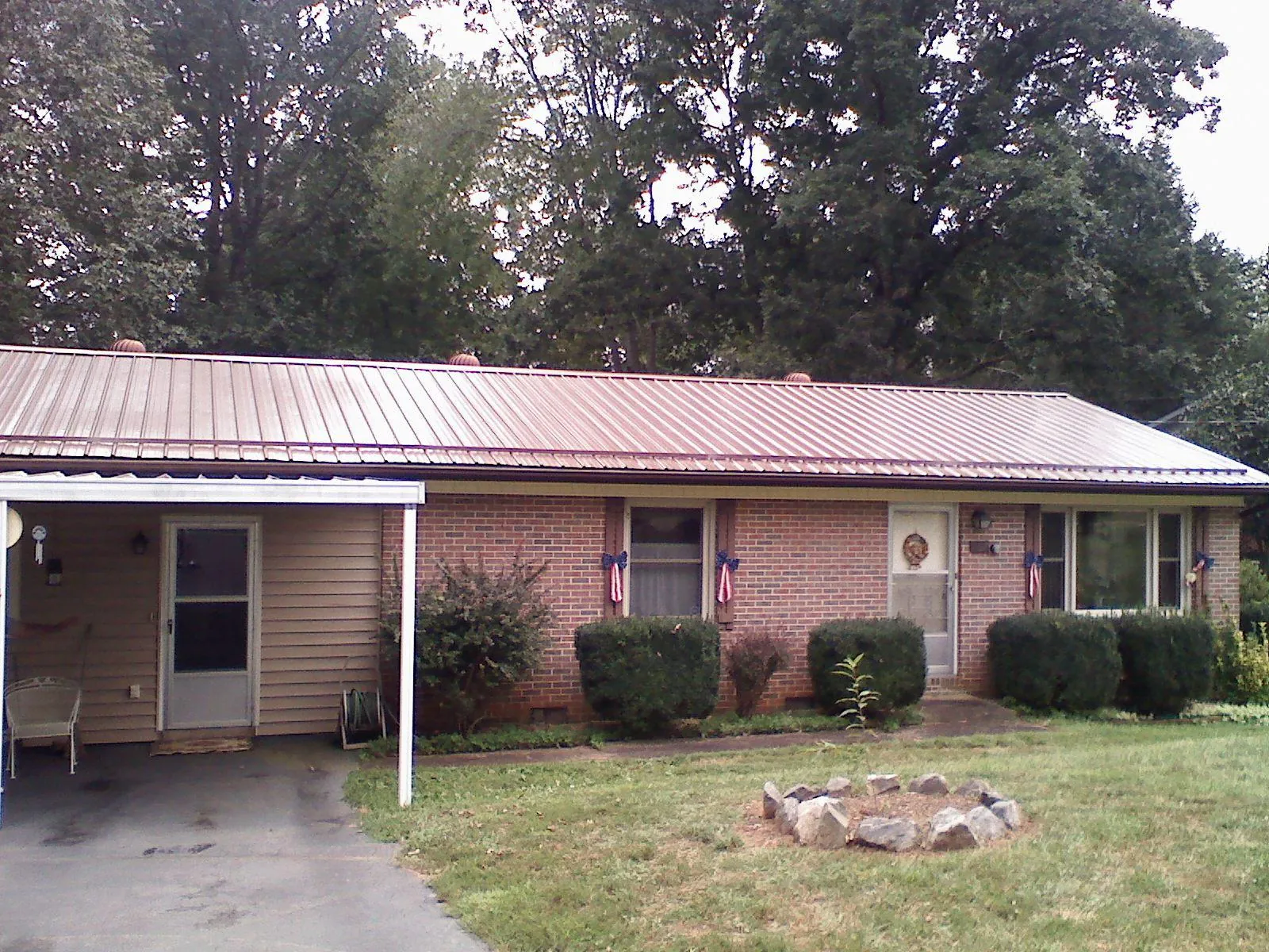 Bronze metal roof and carport on a brick ranch home — Roof Repair work by our crew in Orefield